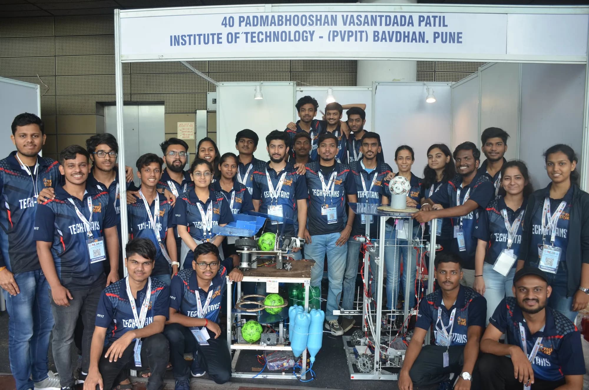 Team Tech Titans in matching jerseys with their two competition robots at the PVPIT booth during DD Robocon 2022.